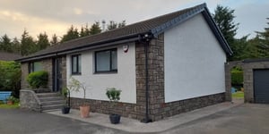 A picturesque house in Scotland, its exterior walls expertly refurbished, now radiating a brand-new and revitalised look.